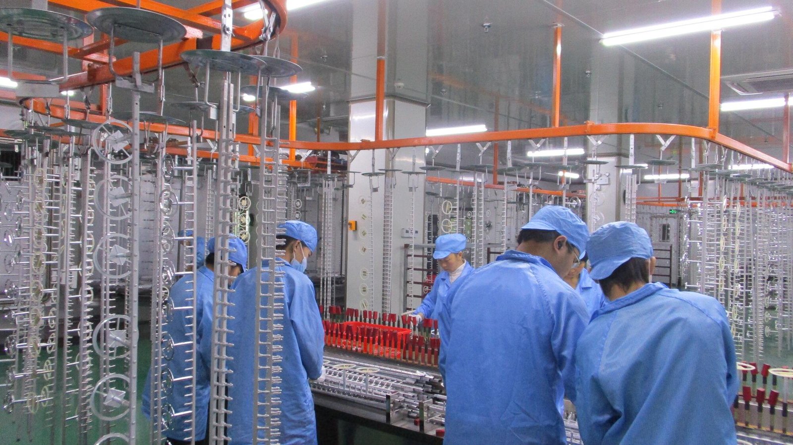 Operators at the spray and decoration line in cleanroom garments